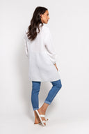 White gauze tunic for women with a button-up front, long sleeves, and a relaxed fit. Lightweight and breathable, perfect for casual wear, layering, and summer outfits.